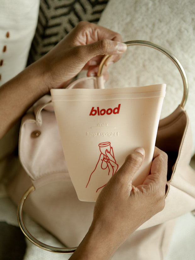 girl taking menstrual cup sanitising pouch out of her handbag 